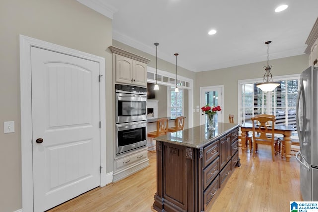 kitchen featuring dark brown cabinets, light wood-type flooring, stainless steel appliances, and ornamental molding