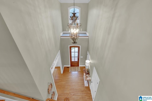 foyer entrance with light wood-type flooring and an inviting chandelier