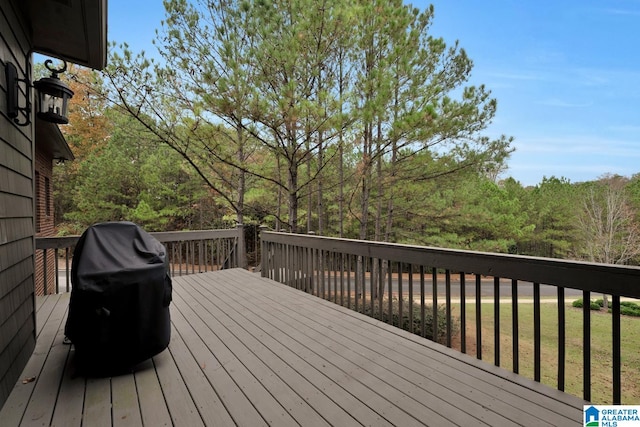 wooden deck featuring grilling area and a yard