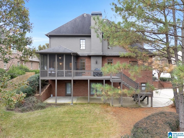 back of property with a patio area, a lawn, a sunroom, and a wooden deck