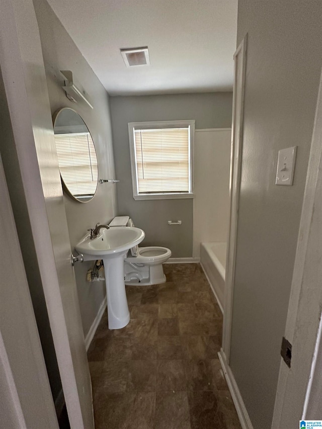 bathroom with a tub and toilet