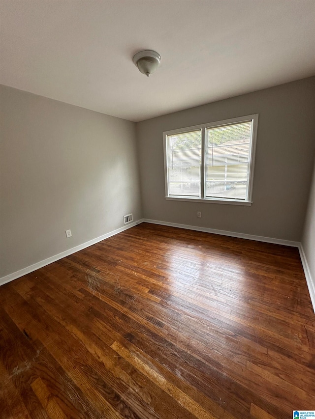 spare room with dark wood-type flooring