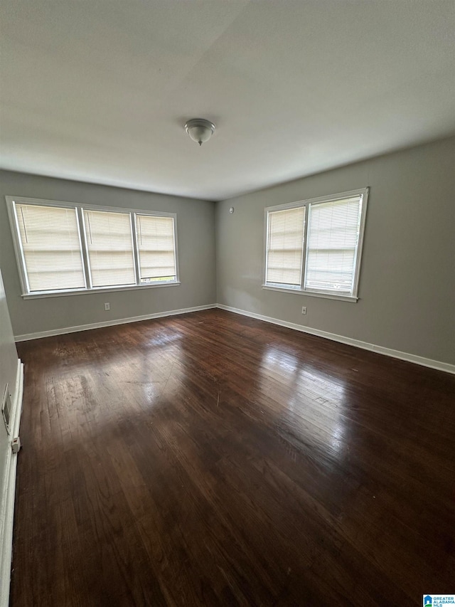 unfurnished room featuring dark hardwood / wood-style flooring and a healthy amount of sunlight