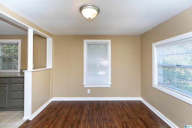 empty room with plenty of natural light and dark hardwood / wood-style flooring