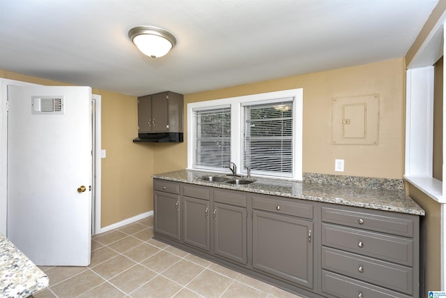 kitchen with light tile patterned floors, gray cabinets, and sink