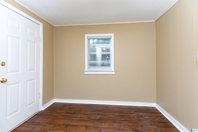 spare room with dark hardwood / wood-style flooring and crown molding