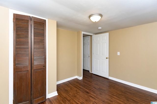 unfurnished bedroom with dark wood-type flooring and a closet