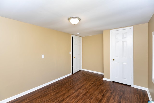 unfurnished room with dark wood-type flooring