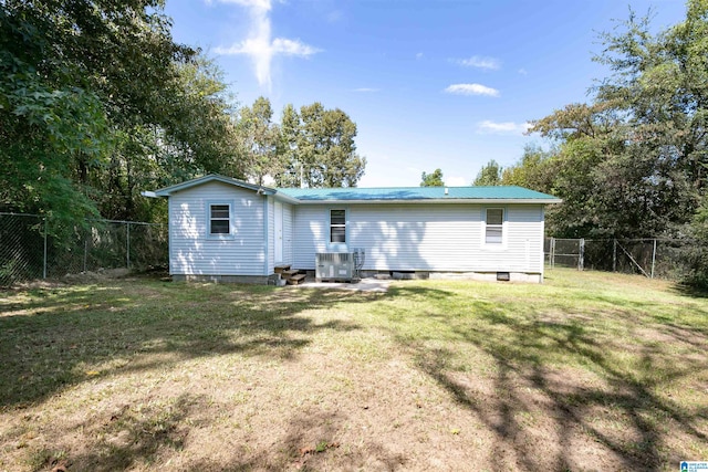 back of house featuring a lawn and cooling unit