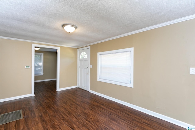 entryway with dark wood-type flooring, a textured ceiling, and ornamental molding