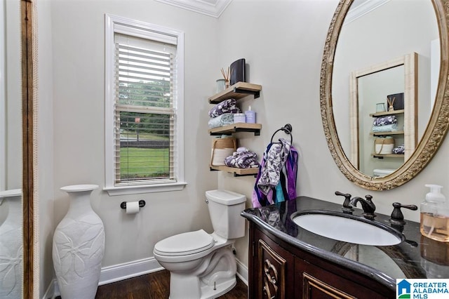 bathroom featuring wood-type flooring, vanity, toilet, and crown molding