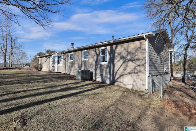 back of property with a yard and central air condition unit