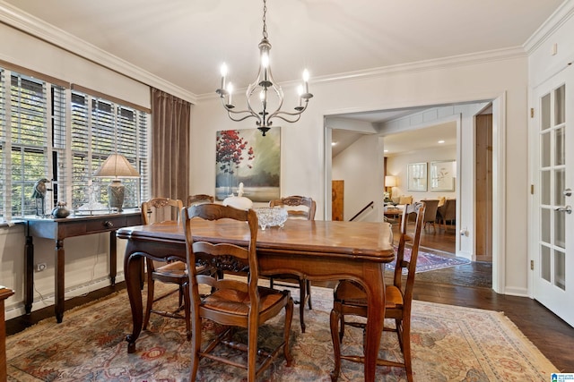 dining space featuring dark wood-type flooring, an inviting chandelier, and ornamental molding