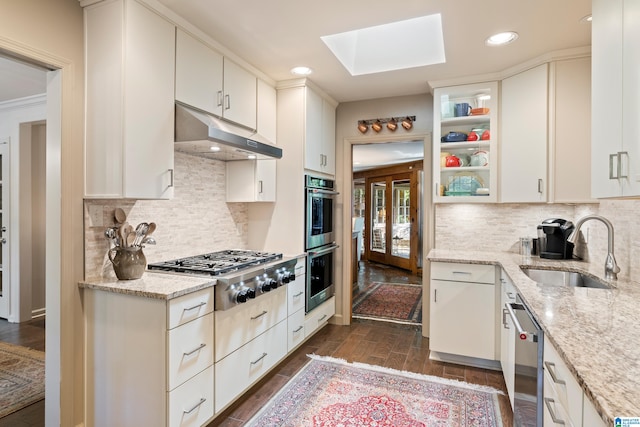 kitchen with stainless steel appliances, dark hardwood / wood-style flooring, light stone countertops, sink, and white cabinets