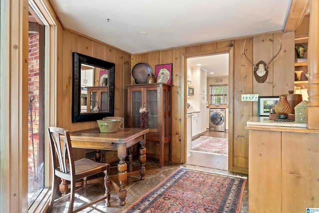 dining area with wooden walls, crown molding, dark hardwood / wood-style floors, and washer / dryer