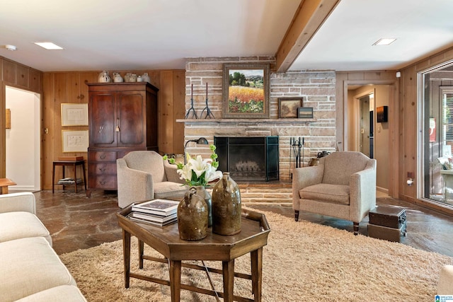 living room with wood walls, beam ceiling, and a fireplace