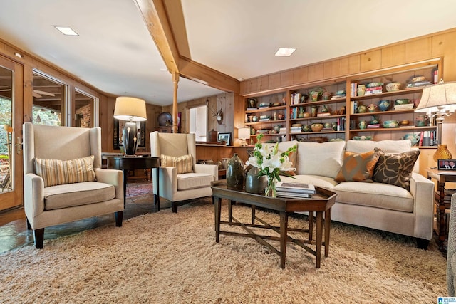 sitting room featuring wooden walls and carpet flooring