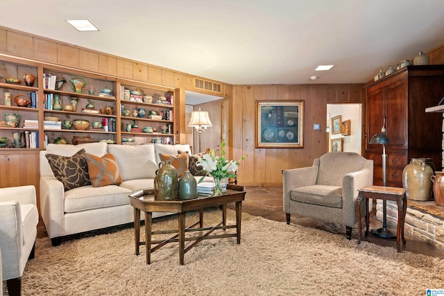 carpeted living room with wood walls