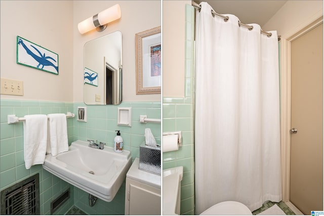 bathroom with a shower with curtain, tile walls, and sink