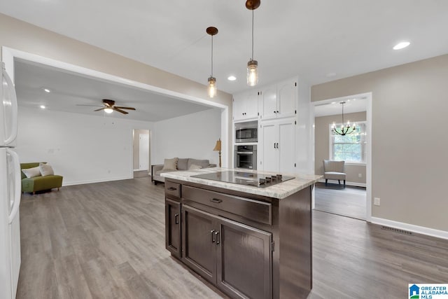 kitchen with dark brown cabinetry, appliances with stainless steel finishes, hanging light fixtures, and light hardwood / wood-style floors