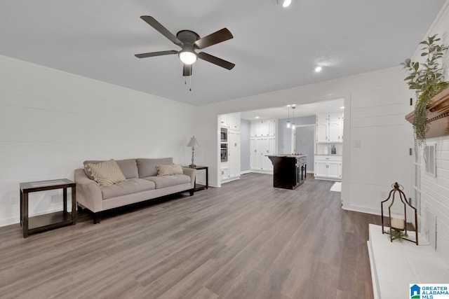 living room with wood-type flooring and ceiling fan