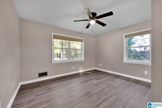 spare room with dark hardwood / wood-style flooring and ceiling fan