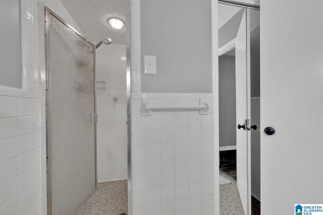 bathroom featuring an enclosed shower and tile walls