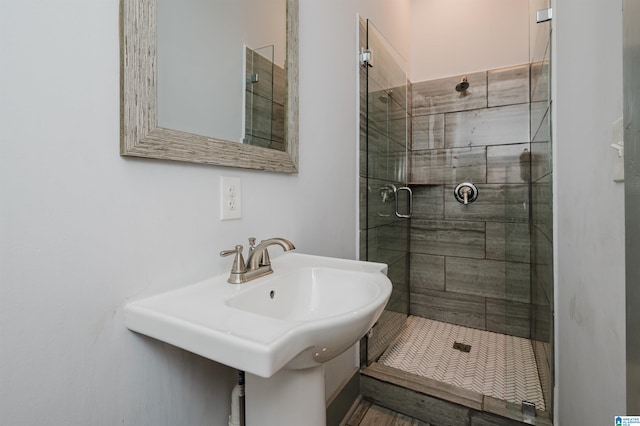 bathroom featuring an enclosed shower and sink