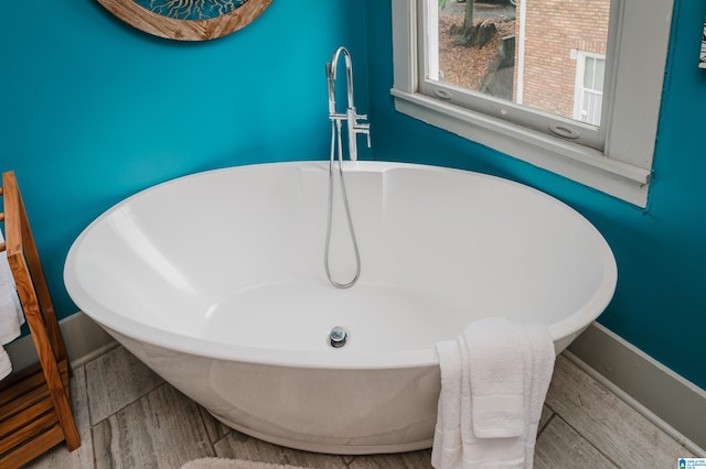 interior details featuring hardwood / wood-style flooring and a bathing tub