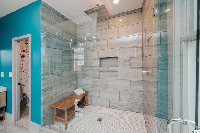 bathroom featuring toilet, tile patterned floors, and a shower with door