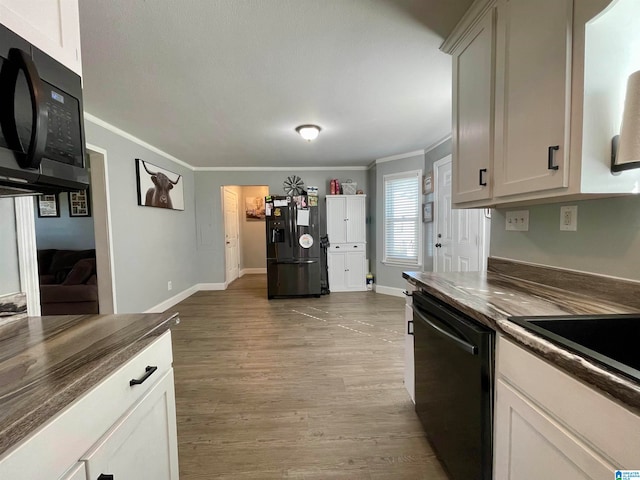 kitchen featuring light hardwood / wood-style floors, wood counters, white cabinetry, and black appliances