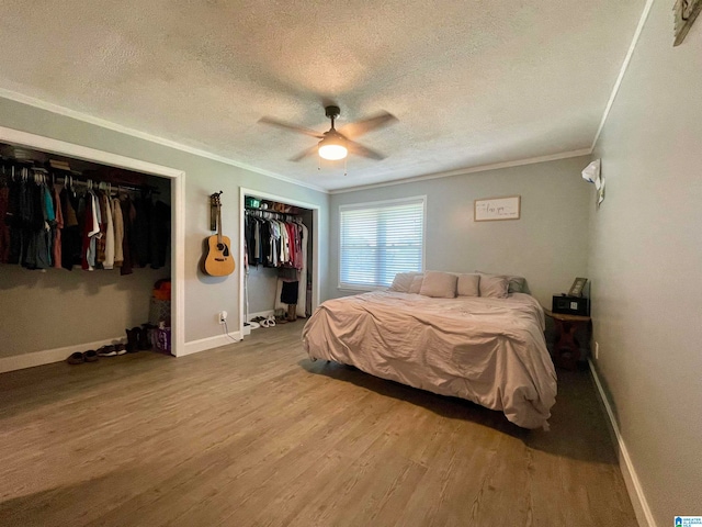 bedroom featuring ceiling fan, ornamental molding, a textured ceiling, and wood-type flooring