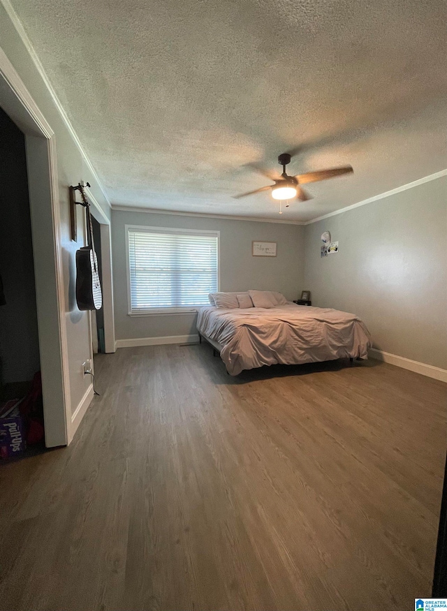 unfurnished bedroom with ornamental molding, ceiling fan, a textured ceiling, and dark hardwood / wood-style floors