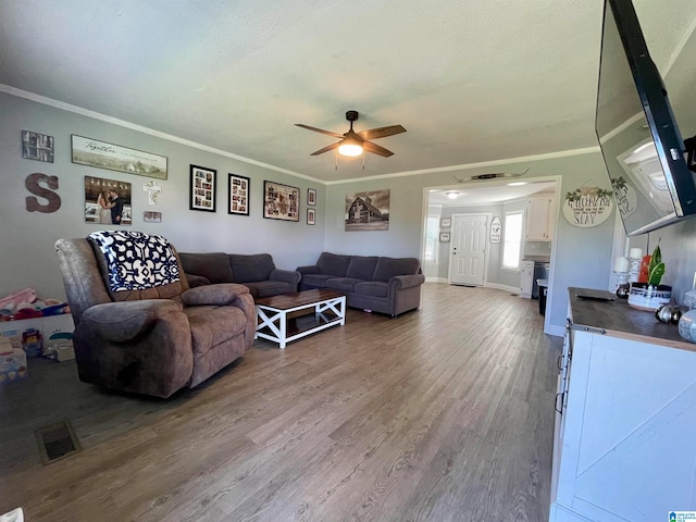 living room with ornamental molding, hardwood / wood-style flooring, and ceiling fan