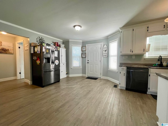 kitchen featuring dishwasher, stainless steel refrigerator with ice dispenser, white cabinets, sink, and light wood-type flooring