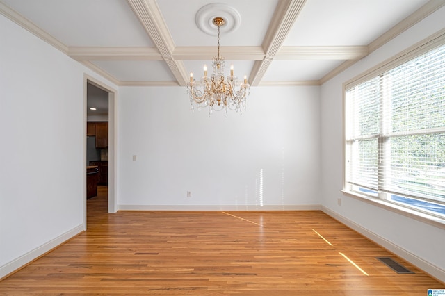 empty room with coffered ceiling, wood-type flooring, a wealth of natural light, and a chandelier