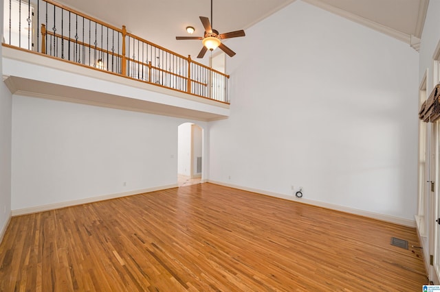 unfurnished living room with hardwood / wood-style flooring, high vaulted ceiling, ceiling fan, and crown molding