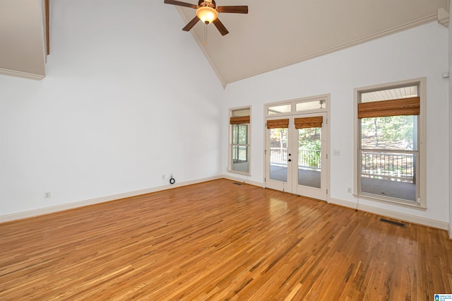 spare room with ceiling fan, light hardwood / wood-style flooring, high vaulted ceiling, and french doors