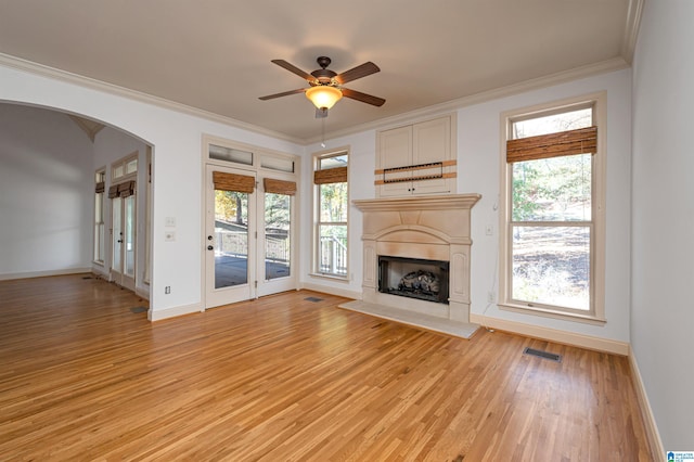 unfurnished living room with light hardwood / wood-style flooring, ceiling fan, and crown molding