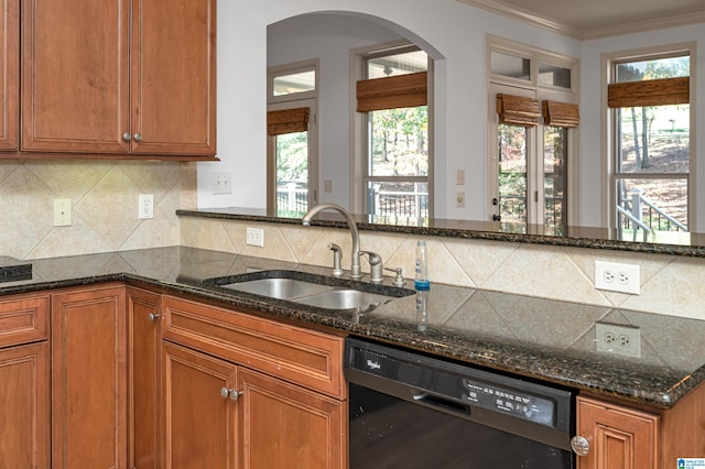 kitchen featuring dishwasher, sink, dark stone countertops, decorative backsplash, and ornamental molding