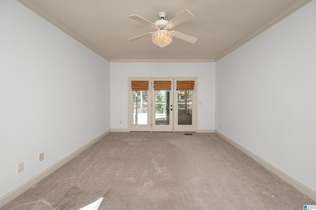 spare room with ceiling fan, crown molding, and light colored carpet