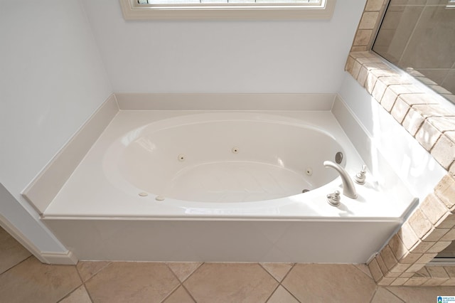 bathroom featuring tile patterned flooring, a bathtub, and a wealth of natural light