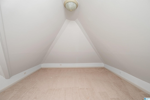 unfurnished room with light colored carpet and lofted ceiling