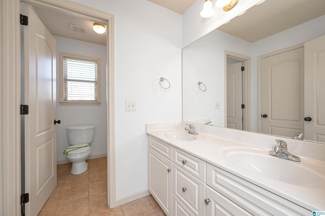 bathroom with tile patterned flooring, vanity, and toilet