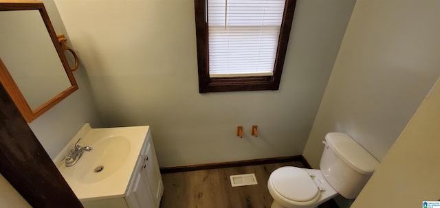 bathroom featuring hardwood / wood-style floors, vanity, and toilet