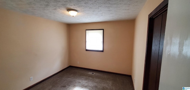 carpeted spare room featuring a textured ceiling