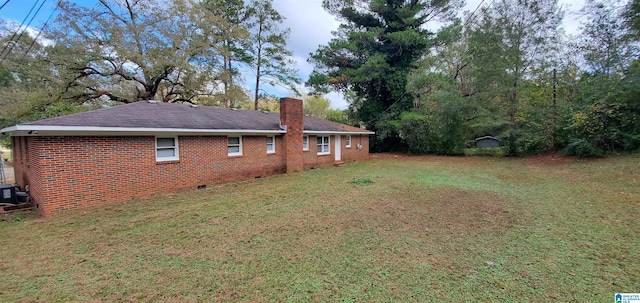 401 Park St E, Sylacauga, AL 35150 - back of house featuring brick siding, a chimney, and a yard