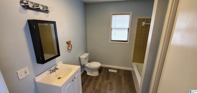 bathroom with toilet, vanity, and wood-type flooring