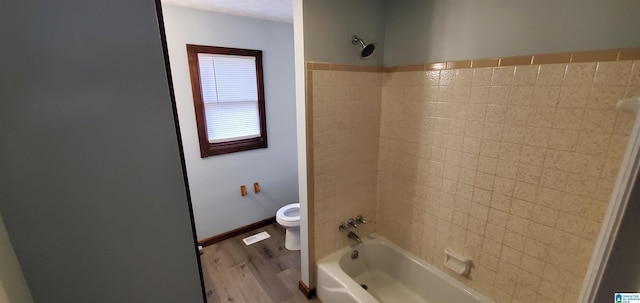 401 Park St E, Sylacauga, AL 35150 - bathroom with toilet, wood finished floors, and washtub / shower combination