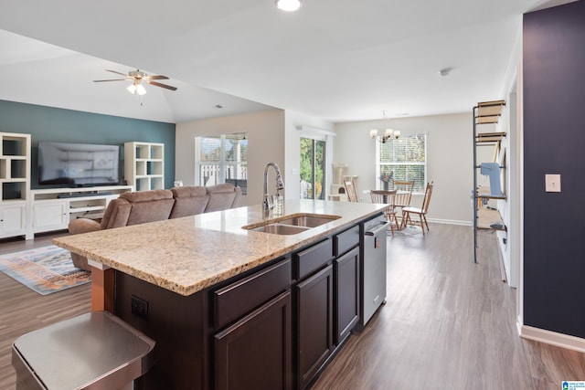 kitchen featuring dark hardwood / wood-style flooring, a center island with sink, sink, and lofted ceiling